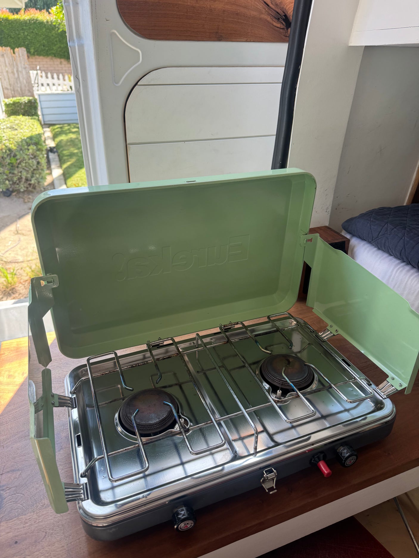 Inside an RV rental, a compact two-burner camping stove is ready for easy meals on the go.