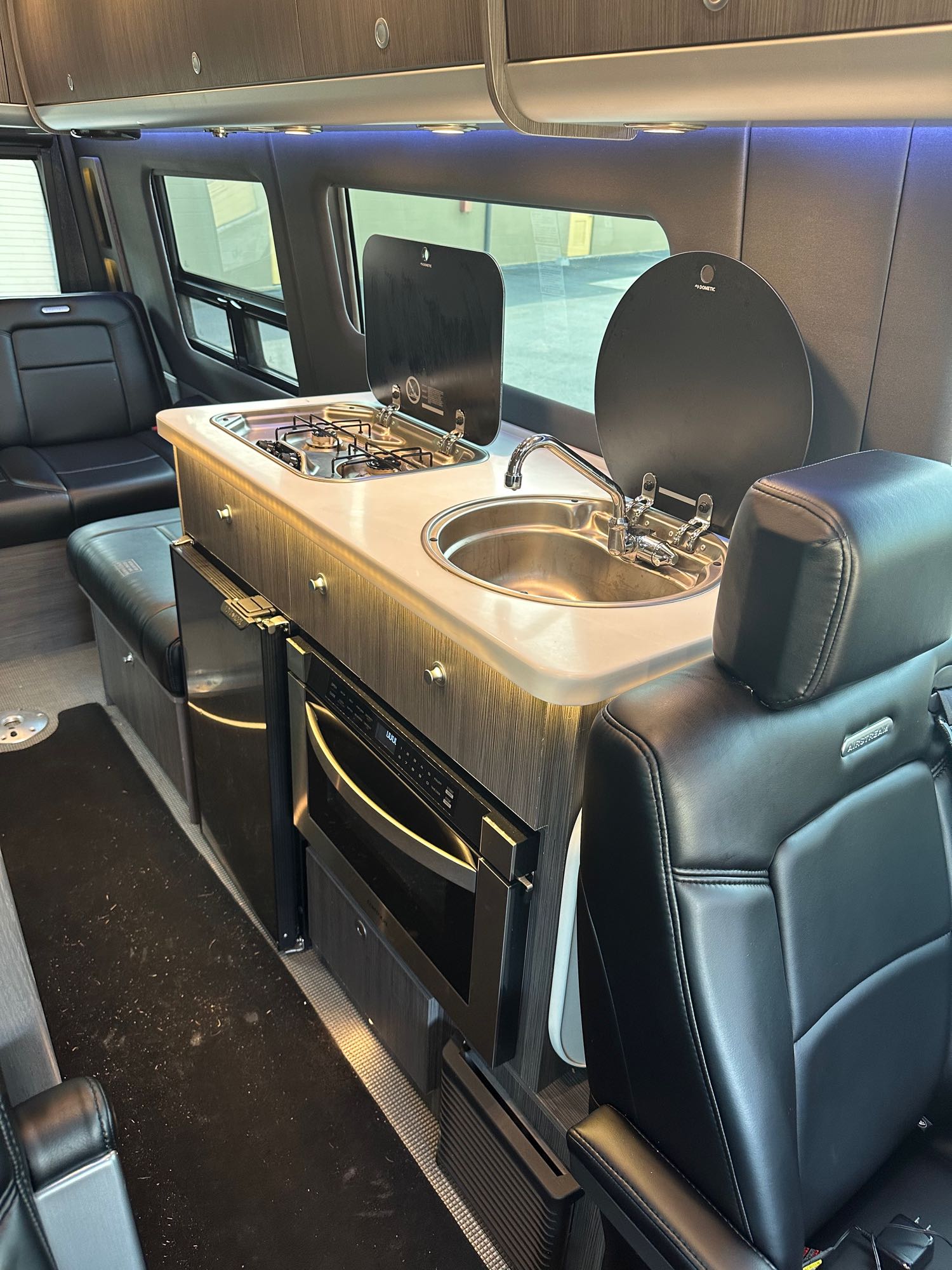 and wall-mounted soap dispensers.|Compact RV rental bathroom: features a toilet