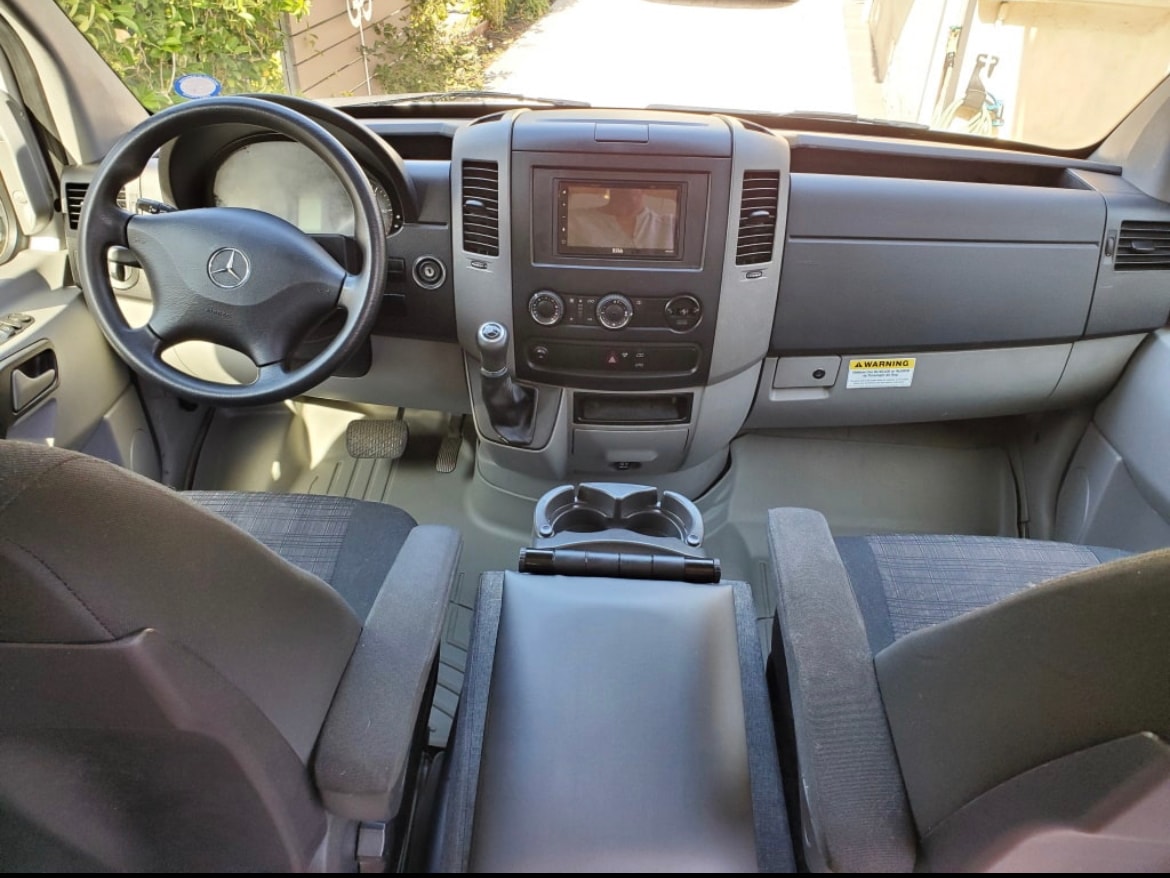 RV rental: Driver's perspective of a Mercedes-Benz Sprinter van interior, showing dashboard, wheel, and seats. — photo 8