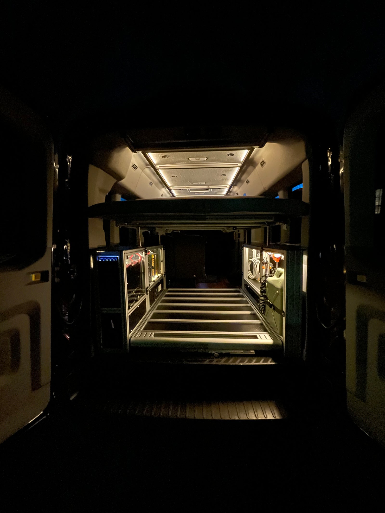 Get a clear view of this rv rental's clever interior design, showcasing smart storage, overhead lighting, and a raised bed.