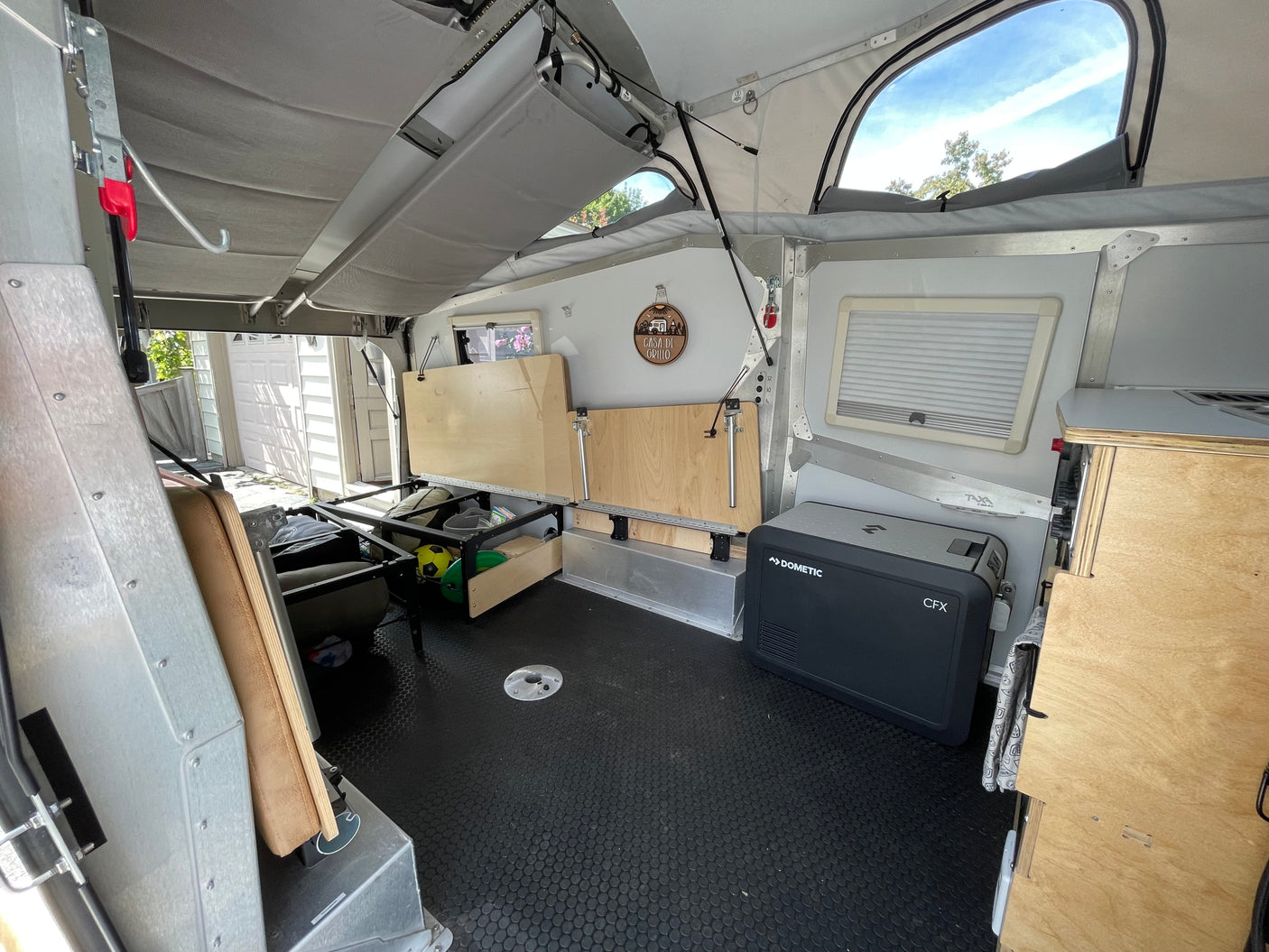 Explore this rv rental's interior featuring a pop-up roof, flexible storage, and a Dometic cooler for your adventures.