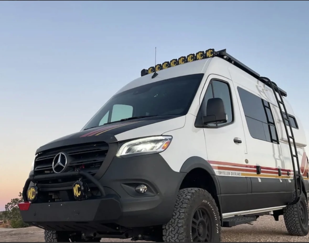 Explore in this rugged custom RV rental. White Sprinter van, off-road ready with lights & ladder for your adventure.