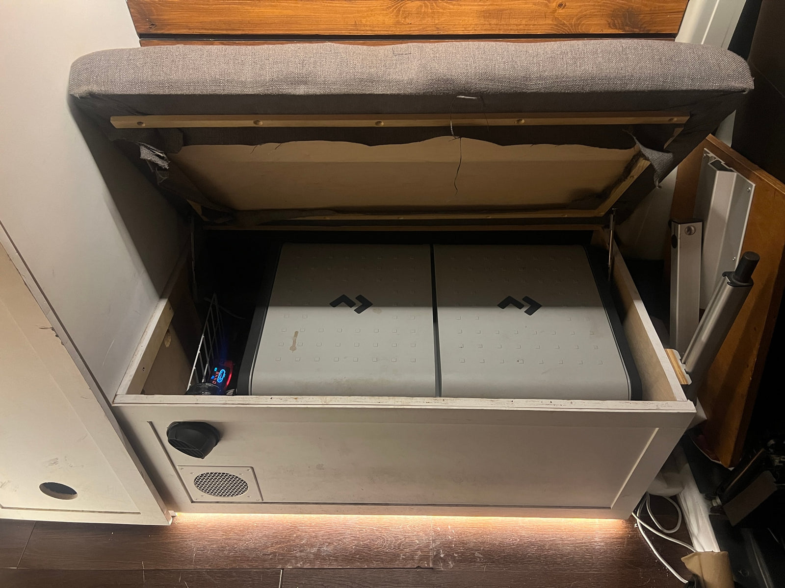 and bright overhead cabinets.|Cozy RV rental interior with grey bench seating