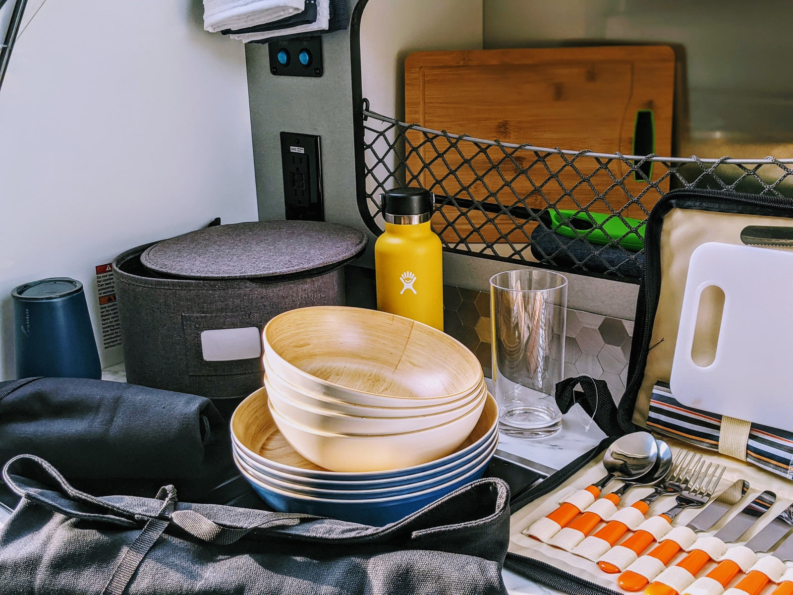 RV rental camp kitchen: Packed with bamboo bowls, Hydro Flask, cutlery, and cutting boards for your next outdoor adventure.