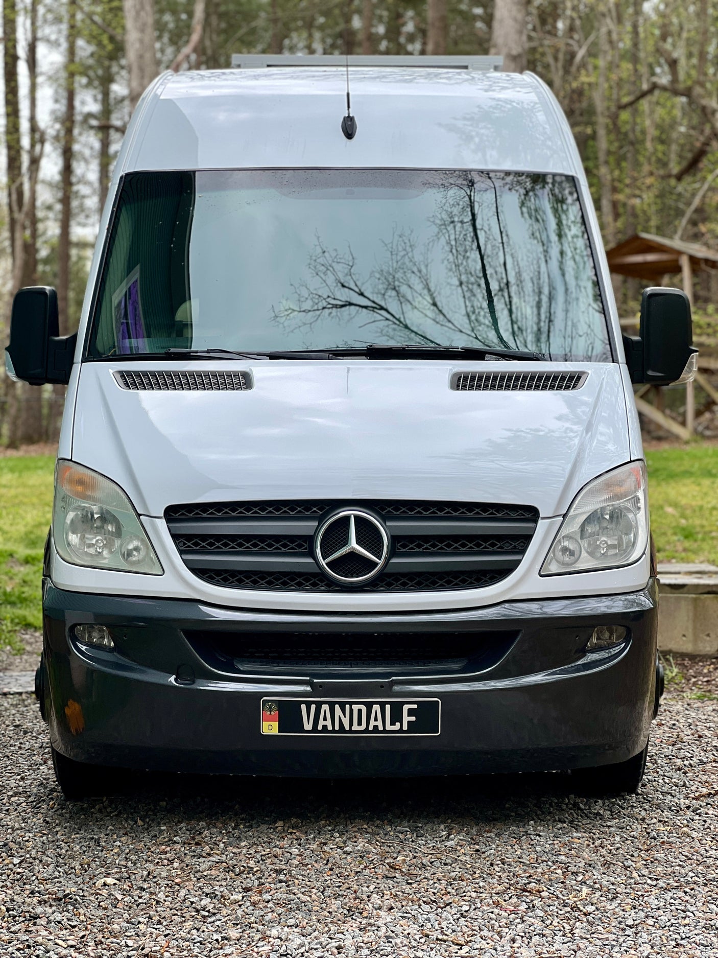 Front view of a white Mercedes Sprinter van with a custom "VANDALF" plate. Ideal for an RV rental, travel, or campervan adventure.