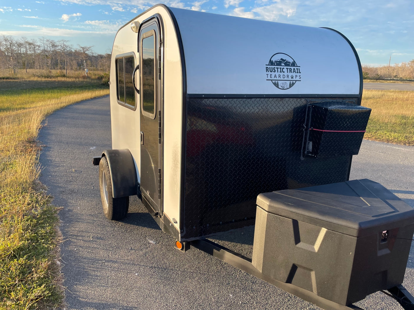 A compact white and black Rustic Trail Teardrop RV rental