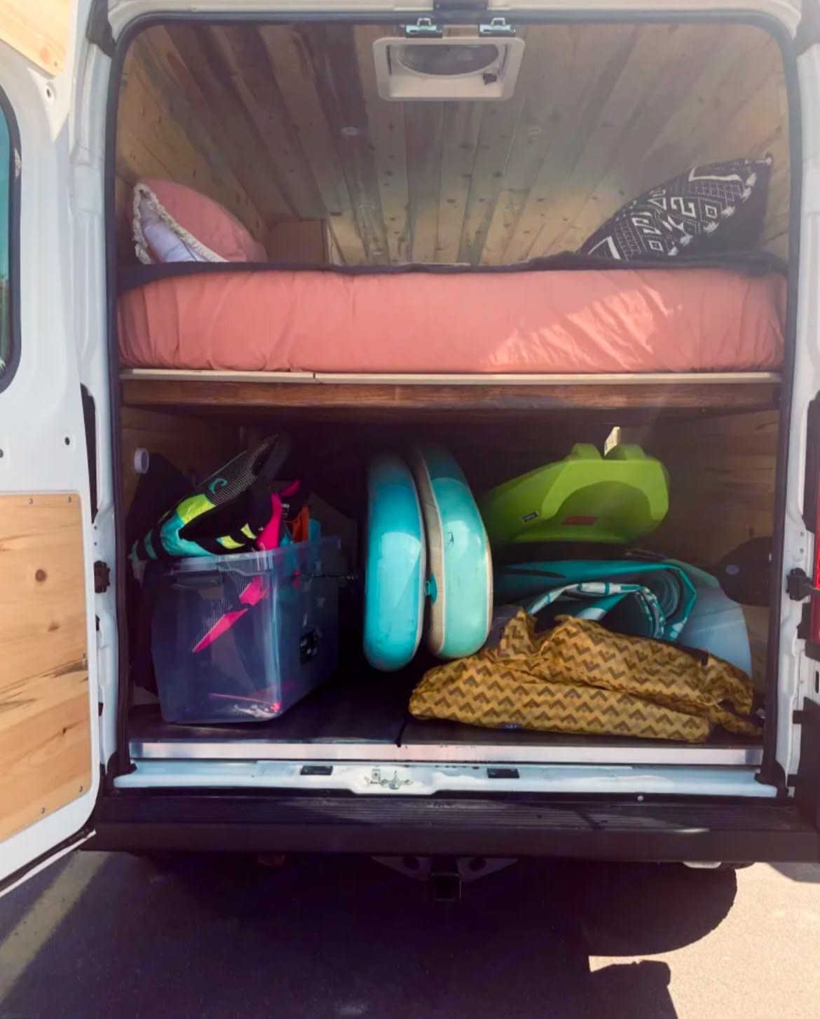 stands with colorful paddleboards by a blue lake