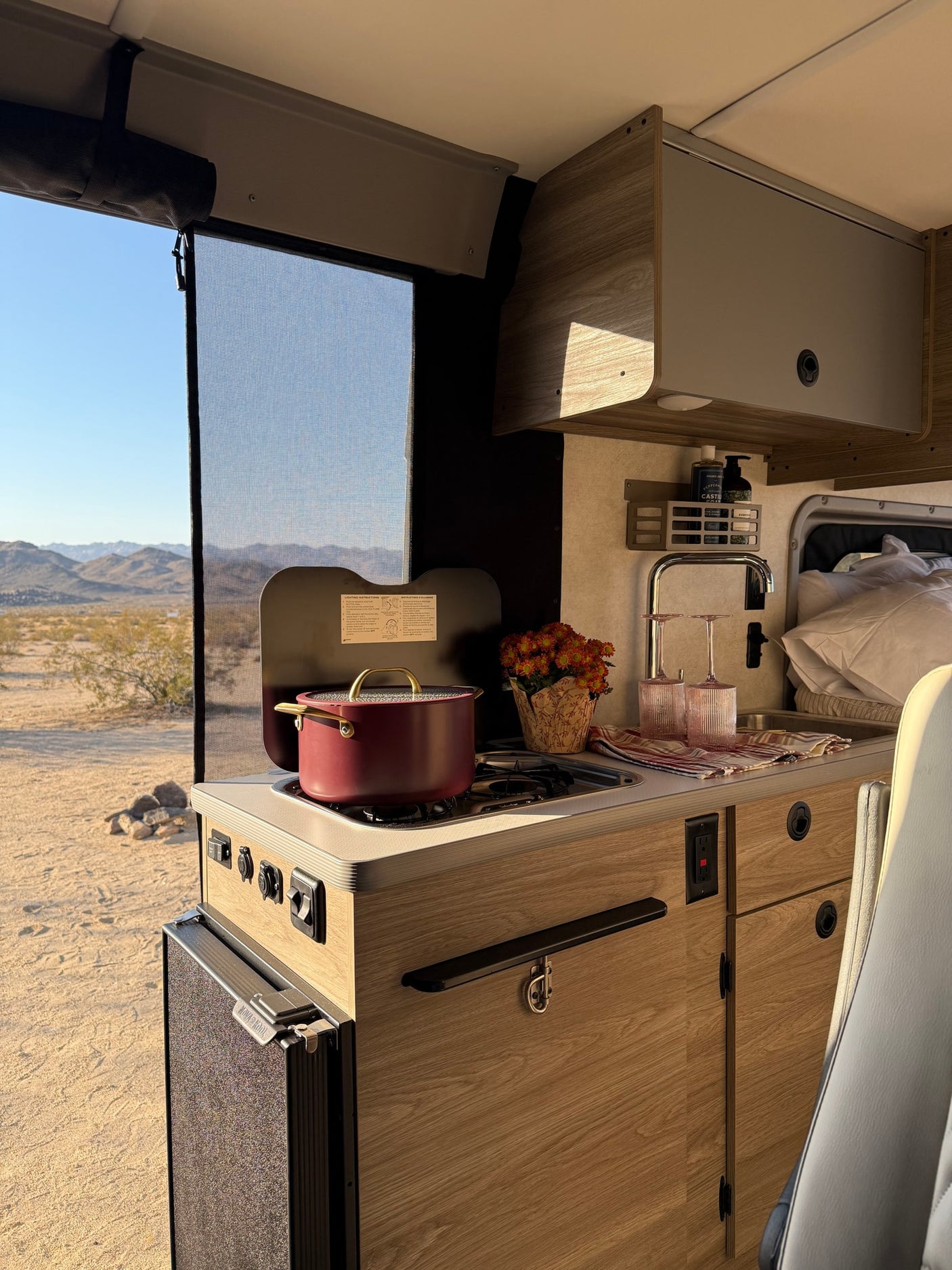 and a warm campfire under a starry sky.|An RV rental camper van is parked in the desert at sunset
