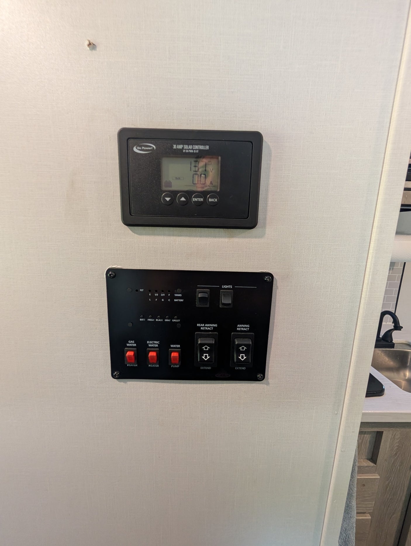 RV rental control panel. Solar controller, tank levels, water heater, water pump, and awning extend/retract switches.