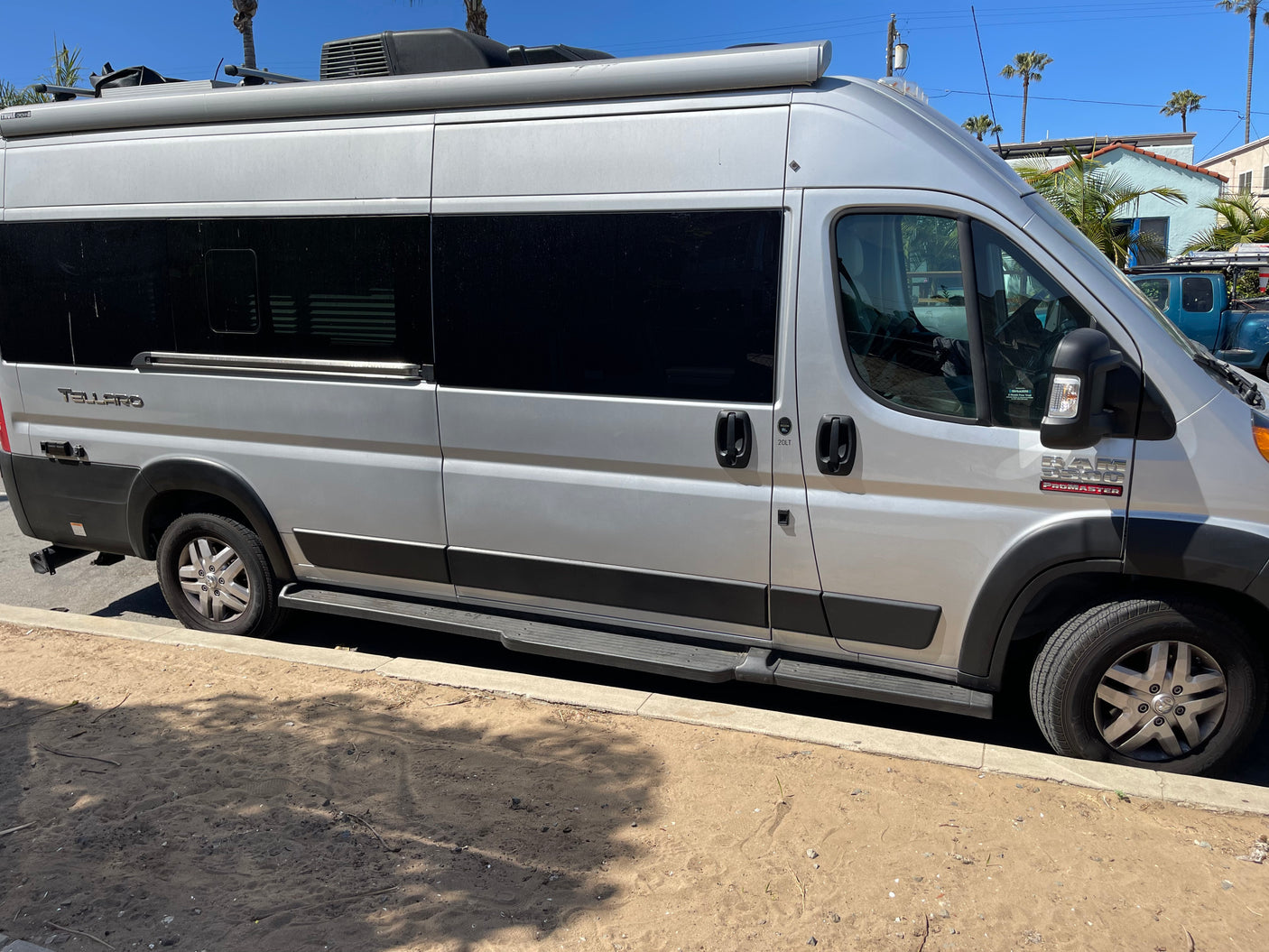 Silver Ram ProMaster Tellaro camper van, ideal for RV rental & road trips, parked on a sunny street.