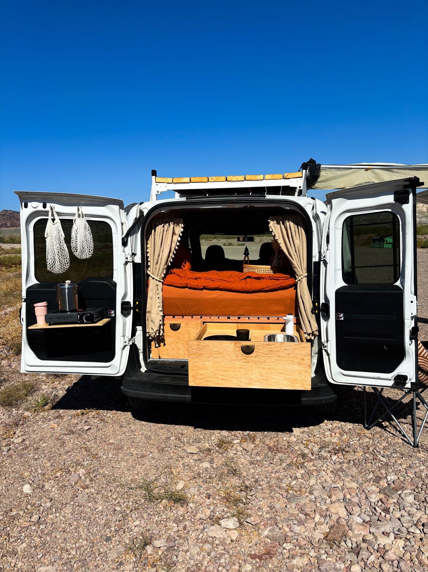 and a rooftop spot for a traveler.|RV rental van interior showcases desert mountains and blue sky — photo 3