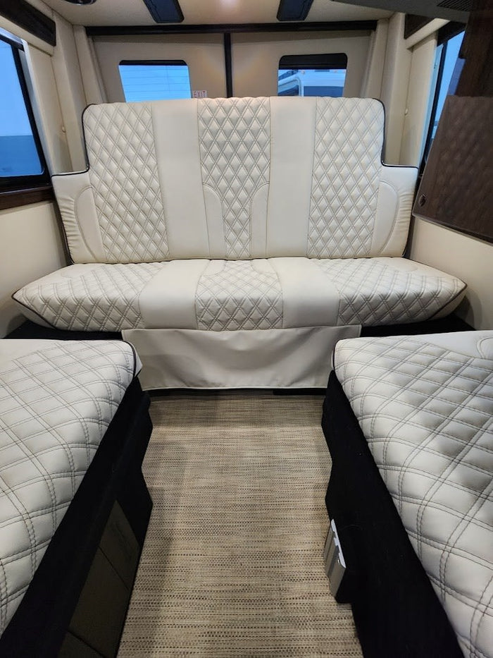 is ready for your next RV rental adventure.|White off-road camper van with extended awning & open door. Your next rv rental adventure awaits!|Luxurious white quilted interior of an RV rental