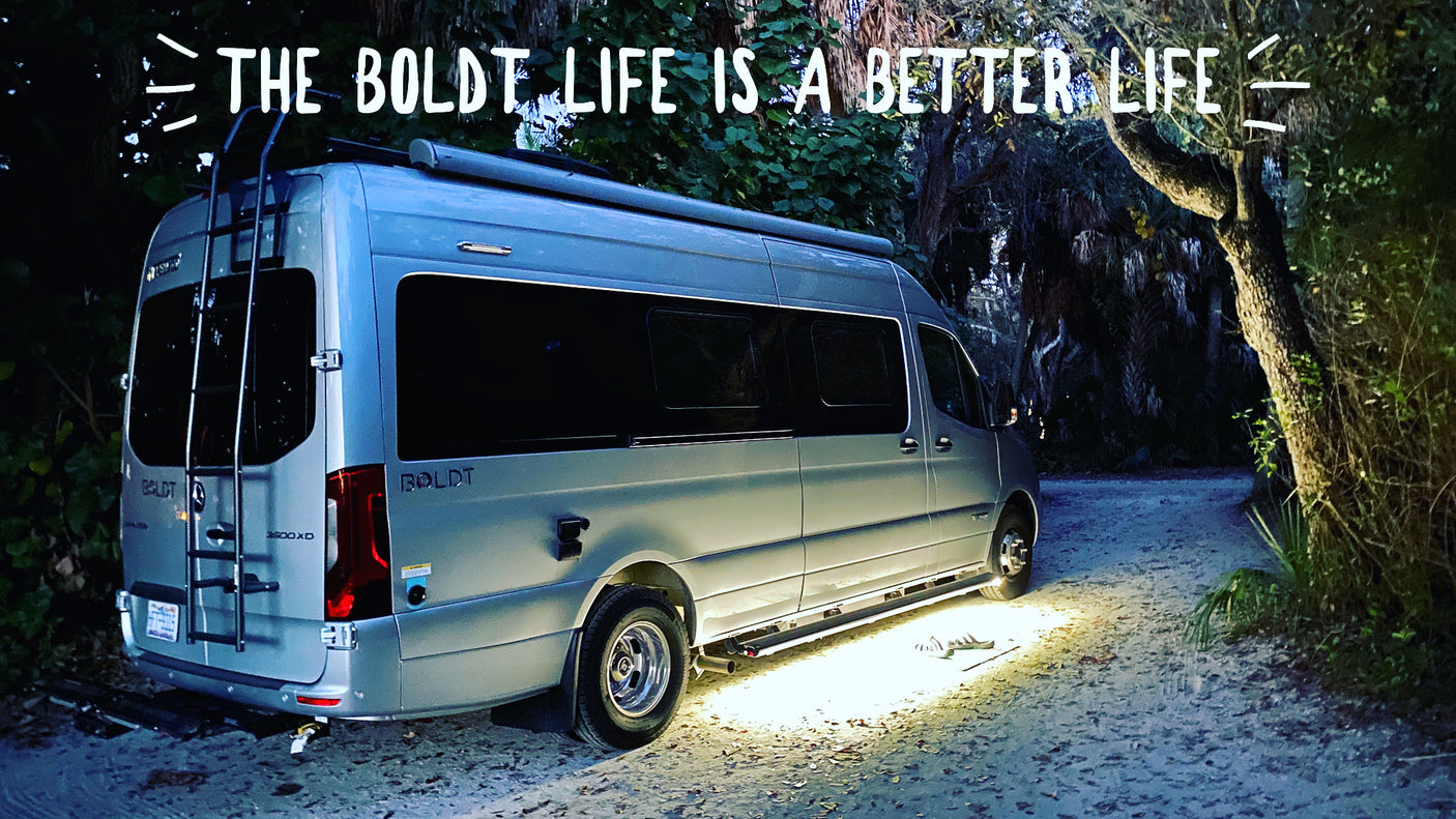 A luxury Airstream Boldt RV rental shines at night on a secluded path, offering a better life for travelers.