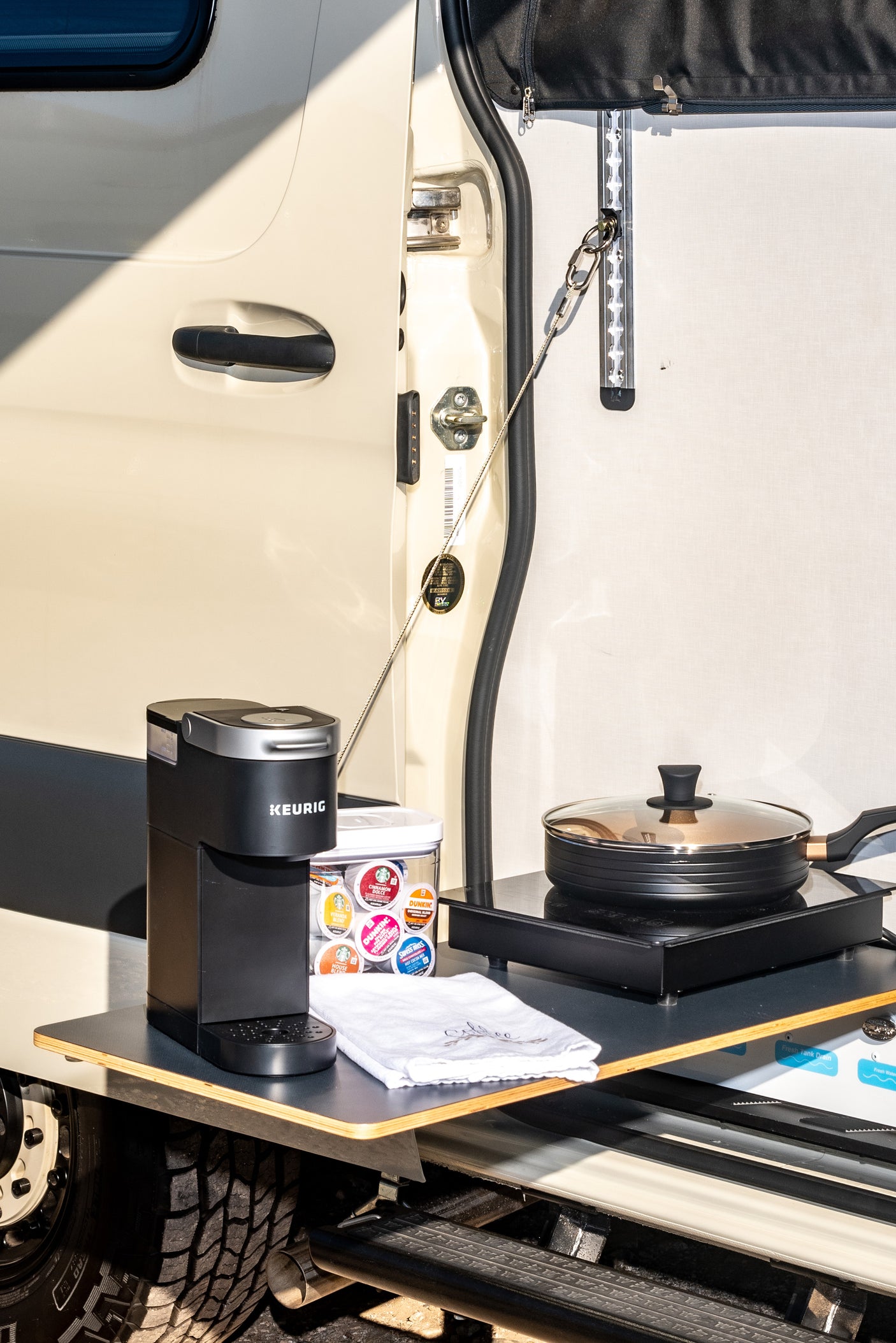 RV rental outdoor kitchen featuring a Keurig coffee maker, cooktop, and pan. Perfect for adventurers on the go.