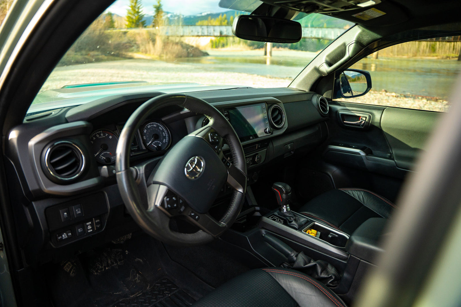perfect for an RV rental and outdoor camping adventures.|Front of a rugged Toyota truck with an Alu-Cab camper
