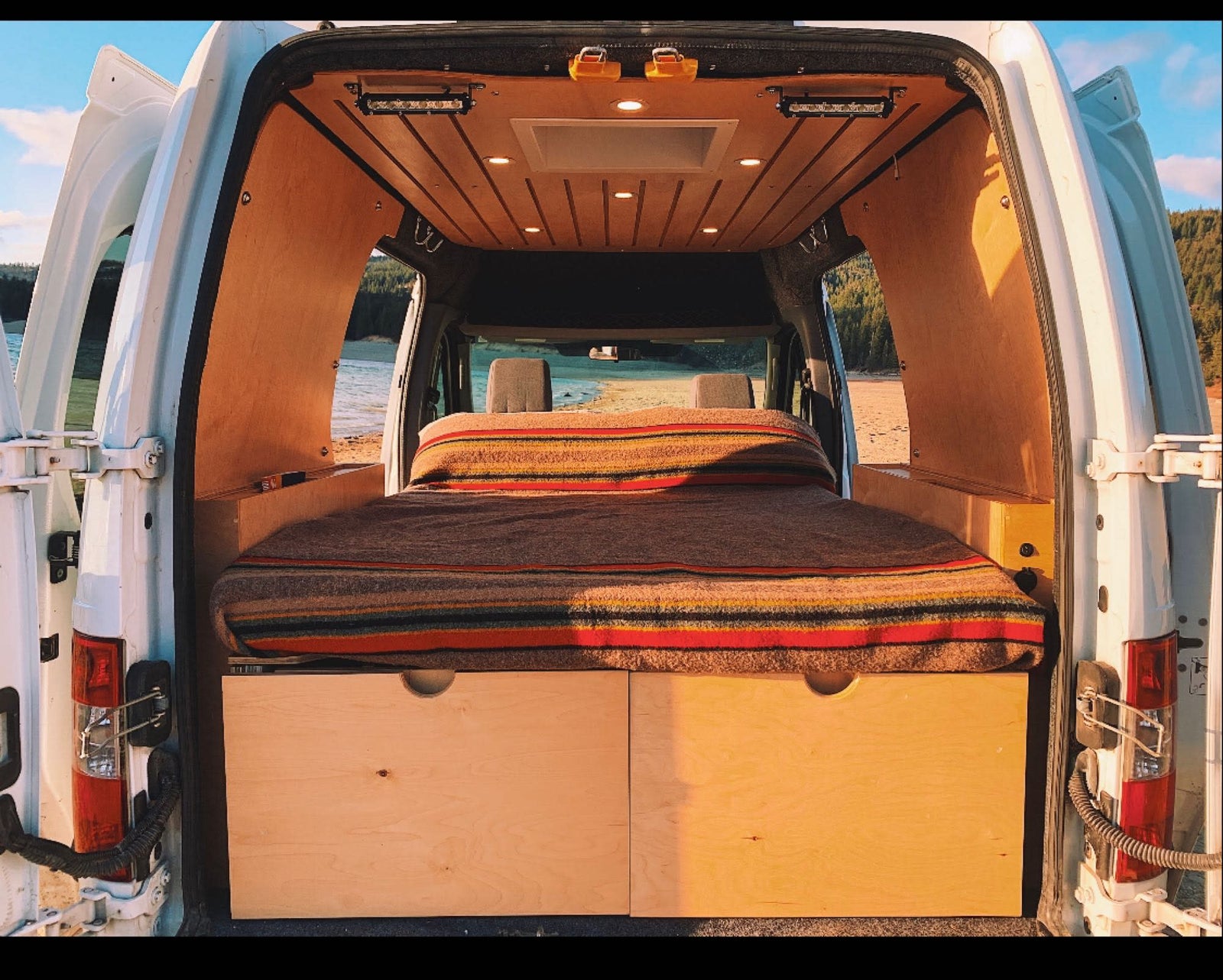 mountains & stunning views.|Cozy RV rental campervan interior: bed