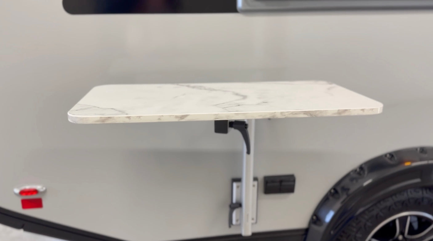 Convenient exterior folding table on an RV rental, perfect for camping and outdoor dining.
