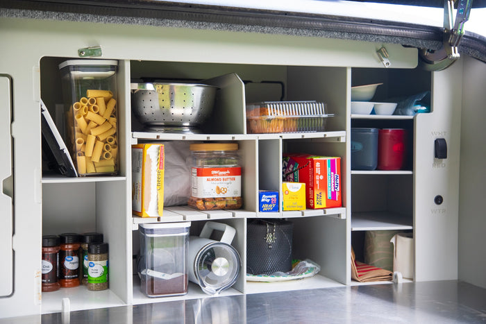ready for convenient outdoor cooking.|Organized RV rental kitchen pantry with shelves holding pasta