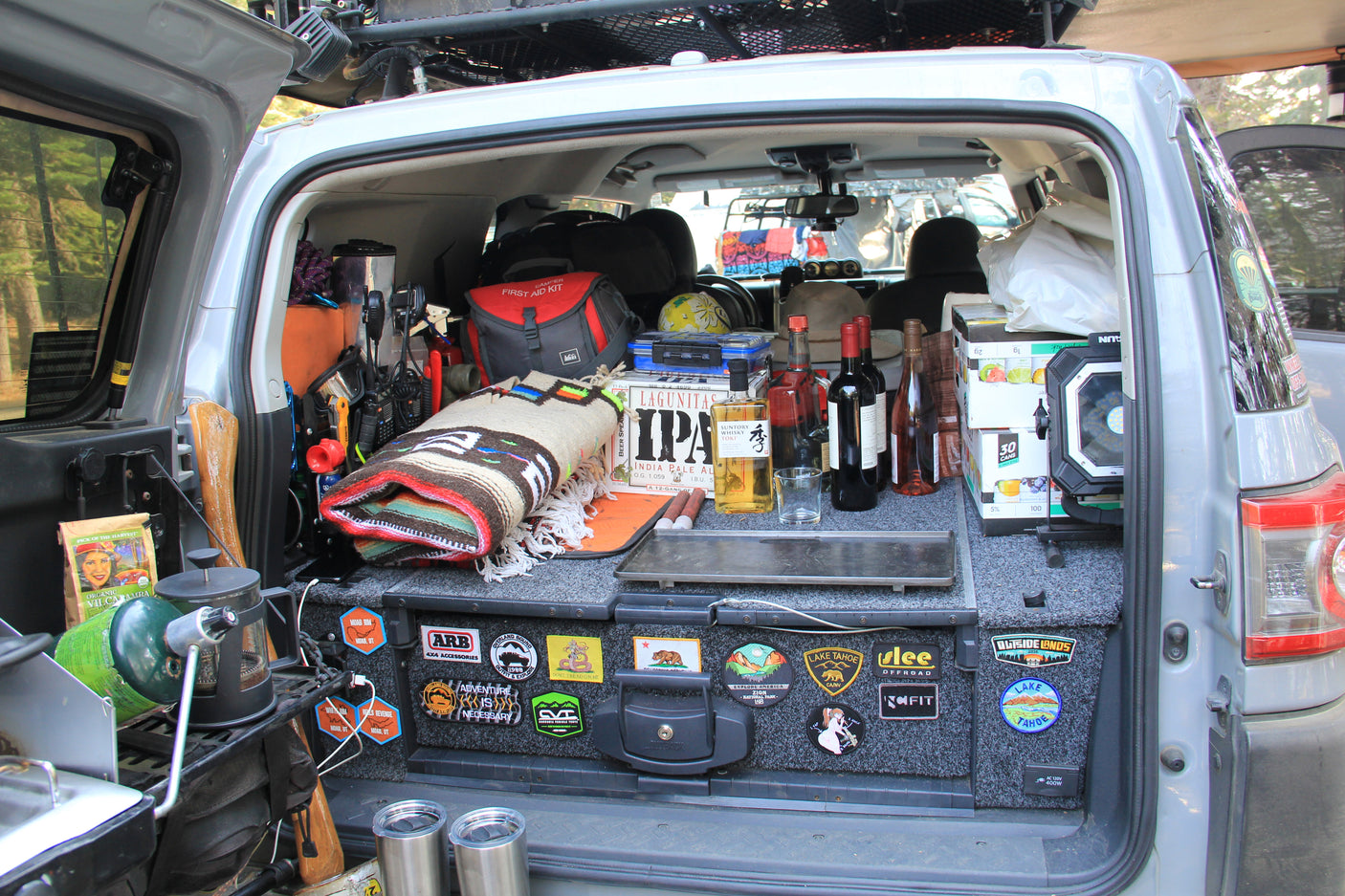 This organized RV rental features a well-equipped trunk with camping gear, a first aid kit, drinks, and cooking supplies for adventure.