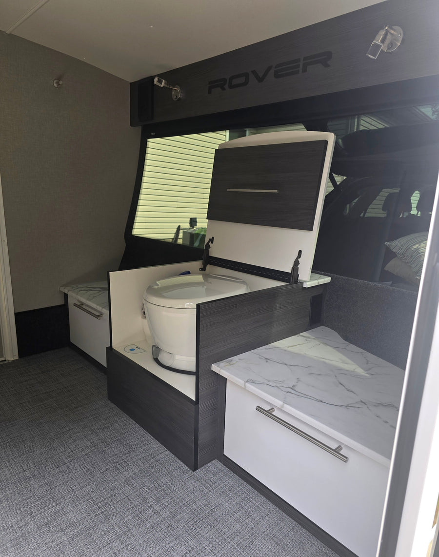 This RV rental showcases a cleverly integrated toilet within sleek cabinetry and ample bench storage.