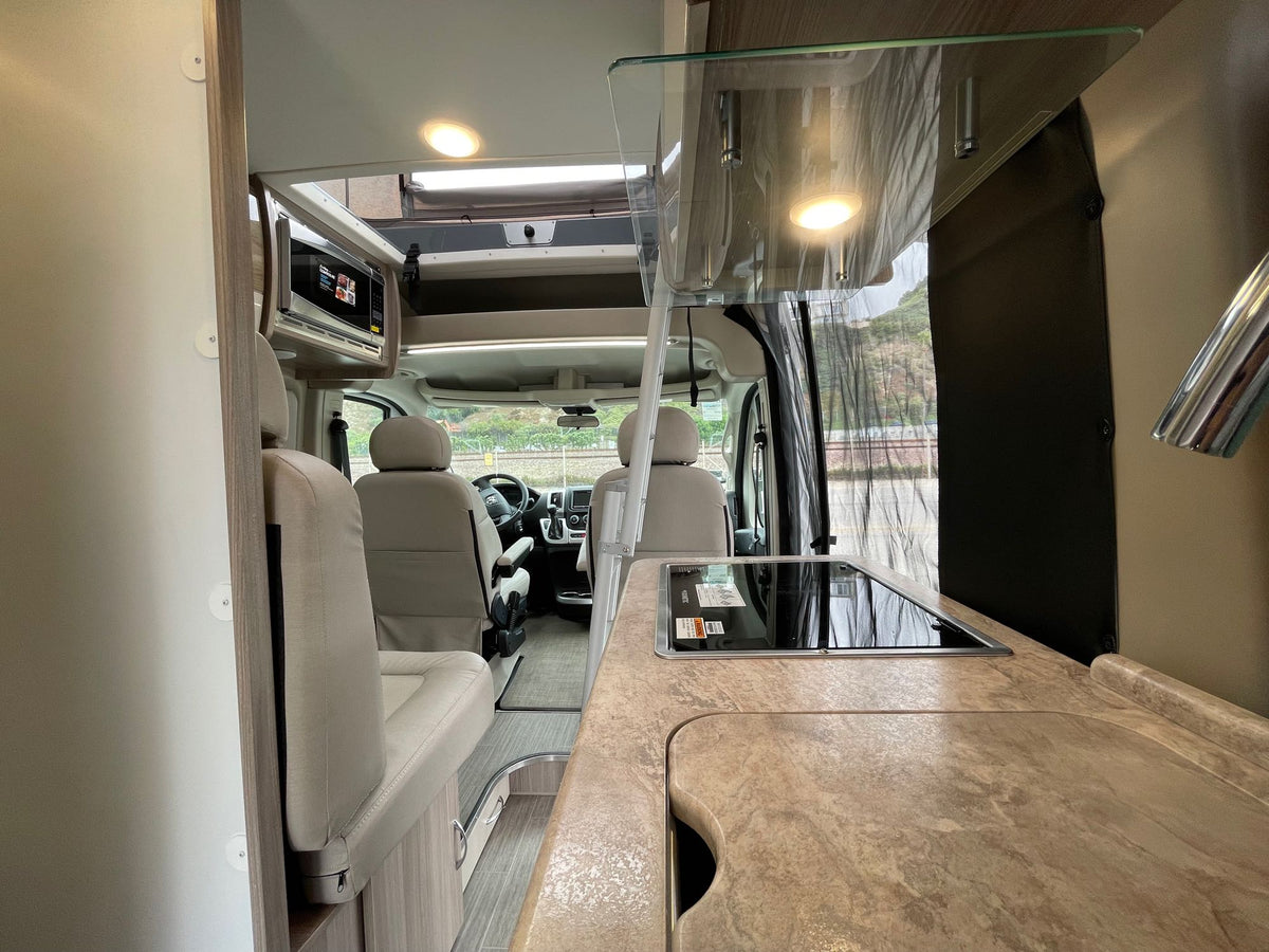 and microwave. Driver's area joins the spacious dining zone.|Spacious RV rental interior with swiveling front seats — photo 9
