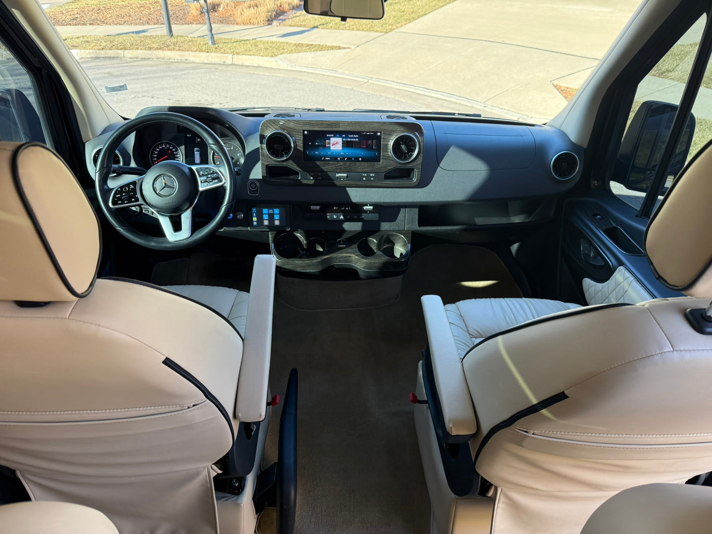 and custom controls for a comfortable journey.|Luxurious RV rental interior: spacious van with swiveling captain's chairs