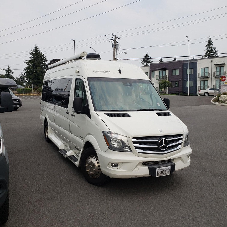 White Mercedes-Benz Sprinter RV rental: a compact Class B motorhome parked outdoors, ready for your next trip.