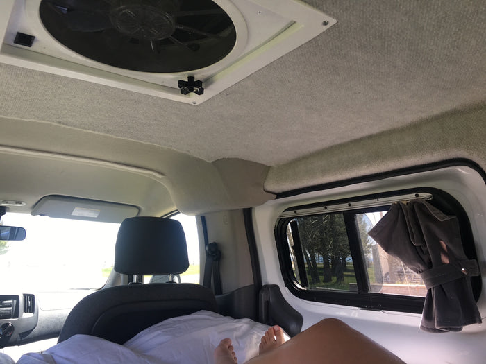 table. Parked in desert.|RV rental: Van interior showing organized bed platform