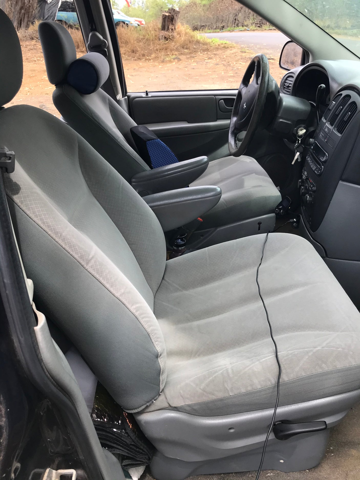 Spacious light gray interior of an RV rental showing the front and second-row seats, dashboard, and steering wheel.