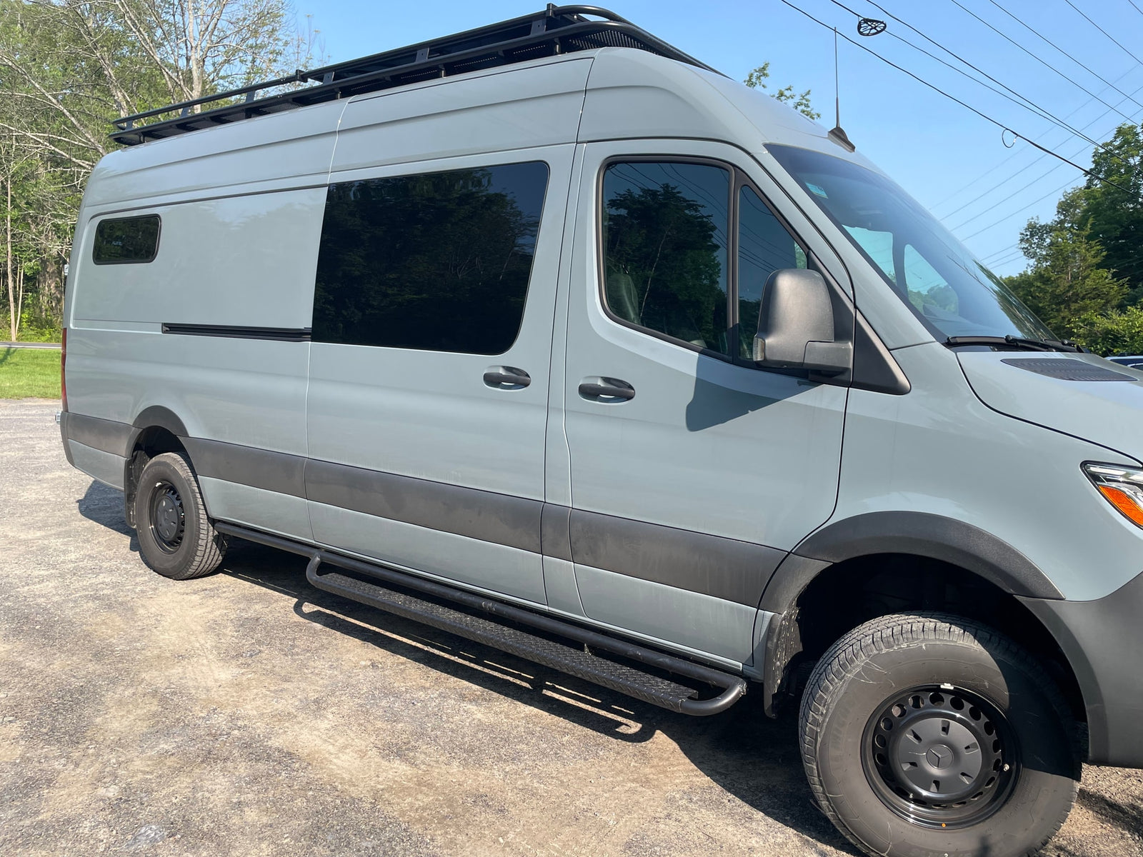 and custom cabinetry for comfort.|RV rental: Sleek bamboo-look storage in a camper van. Open cabinets reveal organized "Laundry" and "Blankets" baskets. Drawers below.|RV rental interior: A bright