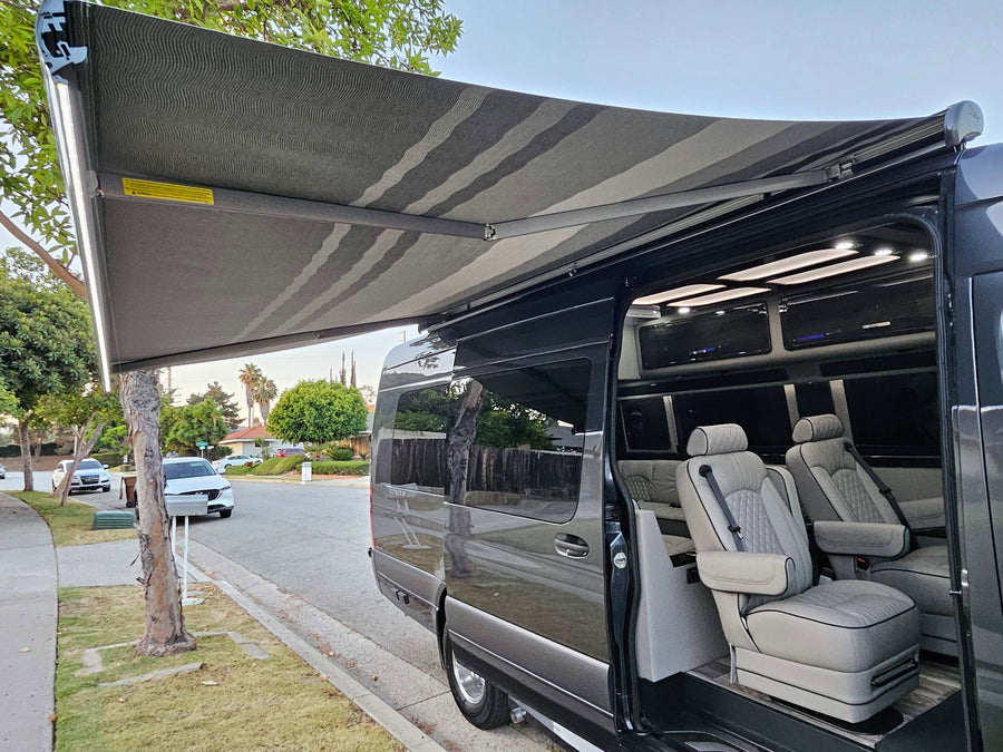 Luxury RV rental van with an extended awning, bright LED lights, and a premium, well-appointed interior.