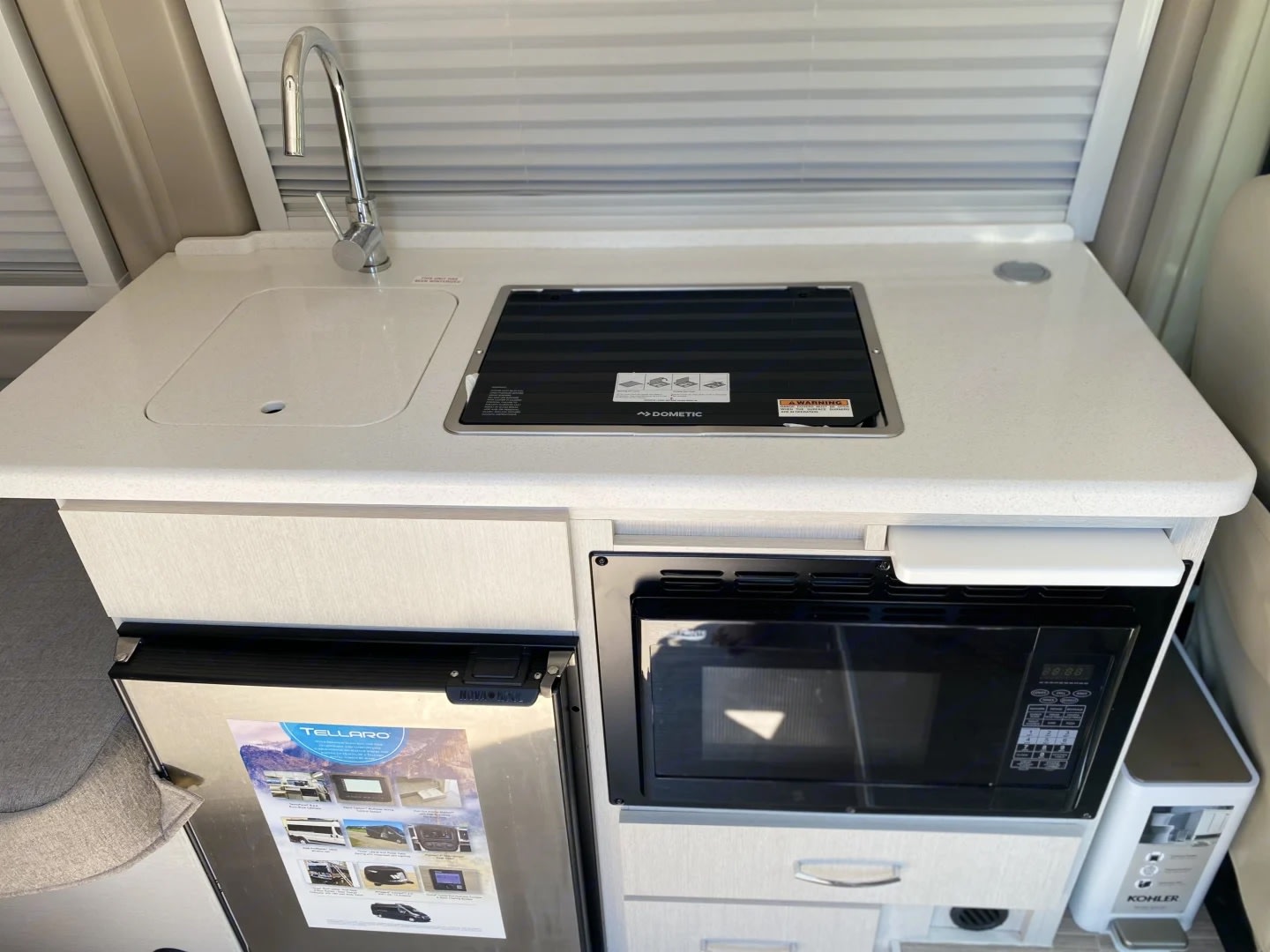 and driver's cab visible.|A modern light grey Ram ProMaster camper van
