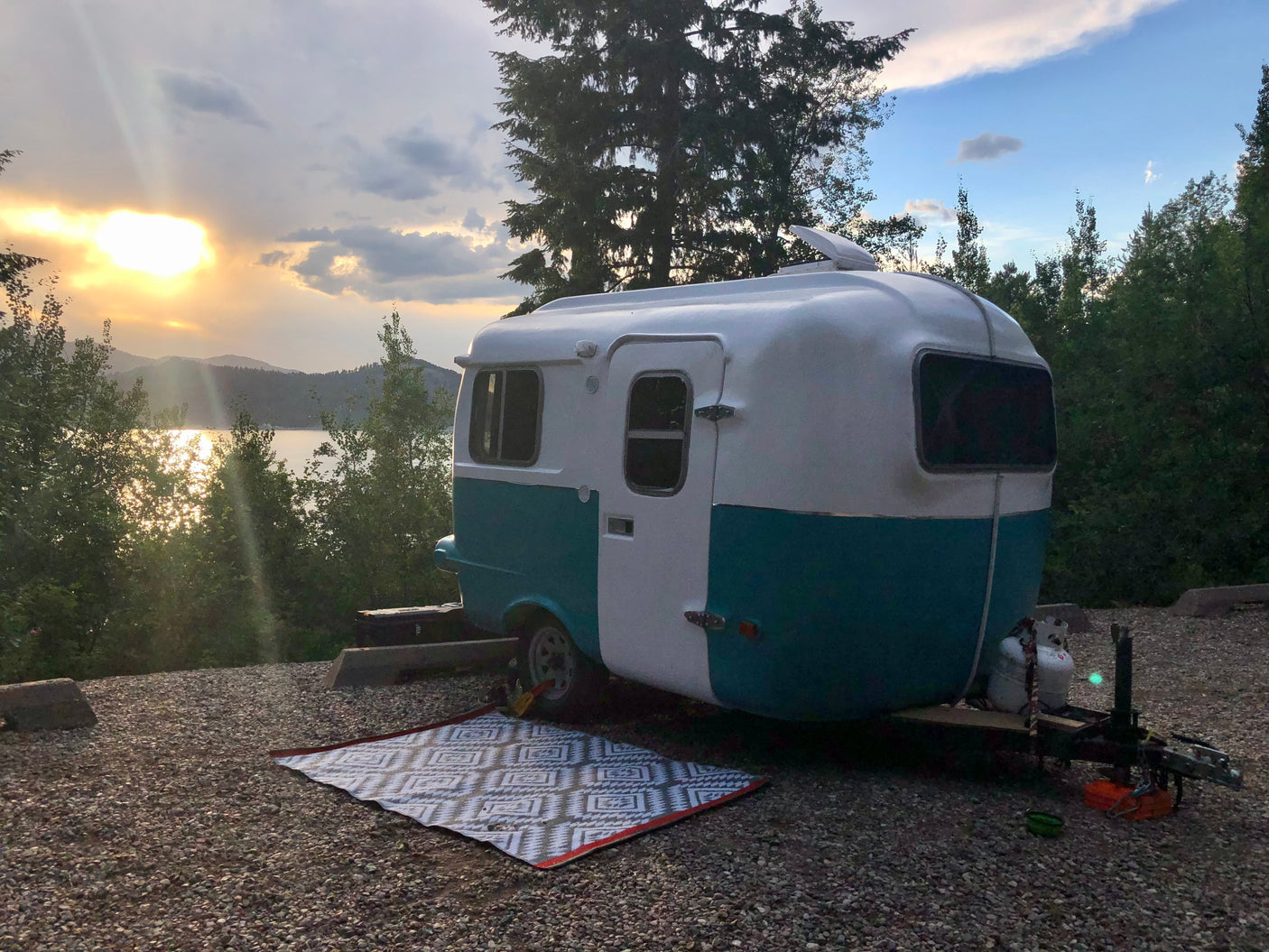 Escape to nature! This charming rv rental offers a scenic lakeside camping experience at golden hour.