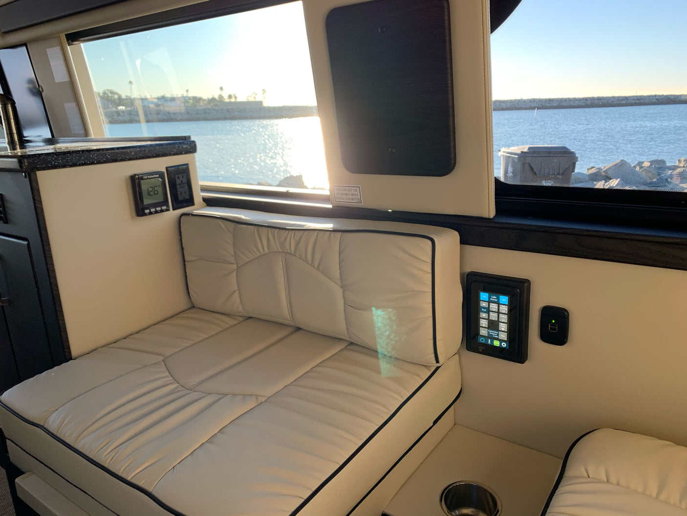 Luxury RV rental interior: spacious cabin with comfy seating, digital controls, & harbor views. Perfect for road trip comfort.