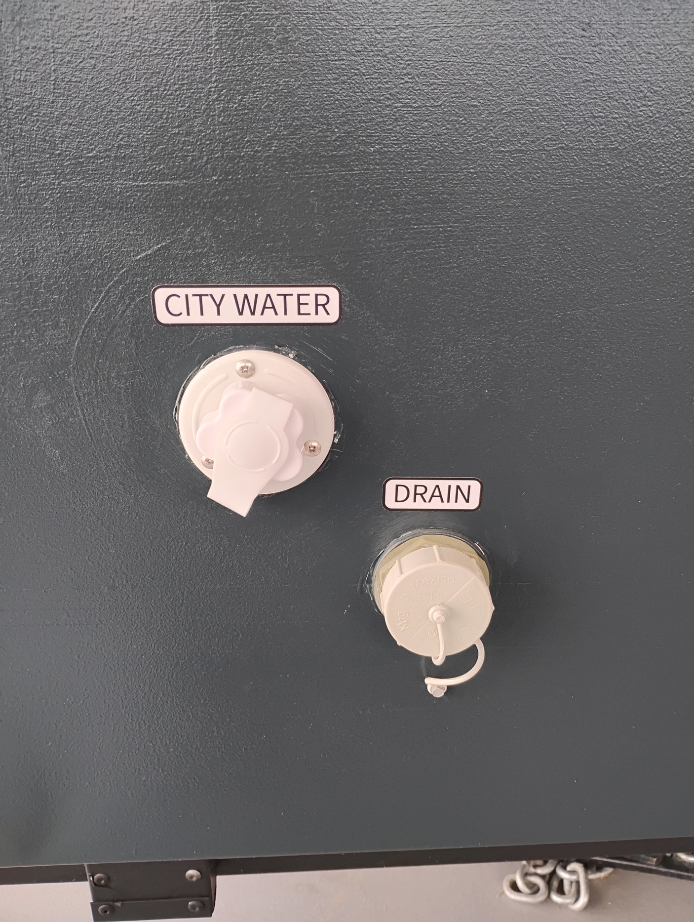 RV rental utility panel showing "CITY WATER" inlet and a "DRAIN" port. Essential for water management.