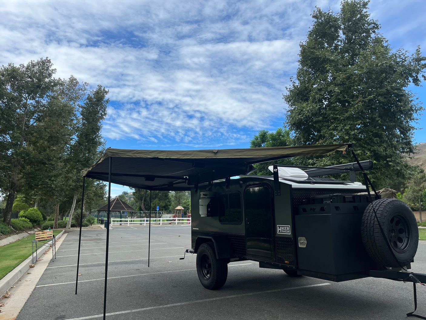 This Hiker Trailer RV rental, a rugged teardrop camper with an awning, is ideal for outdoor travel and camping adventures.