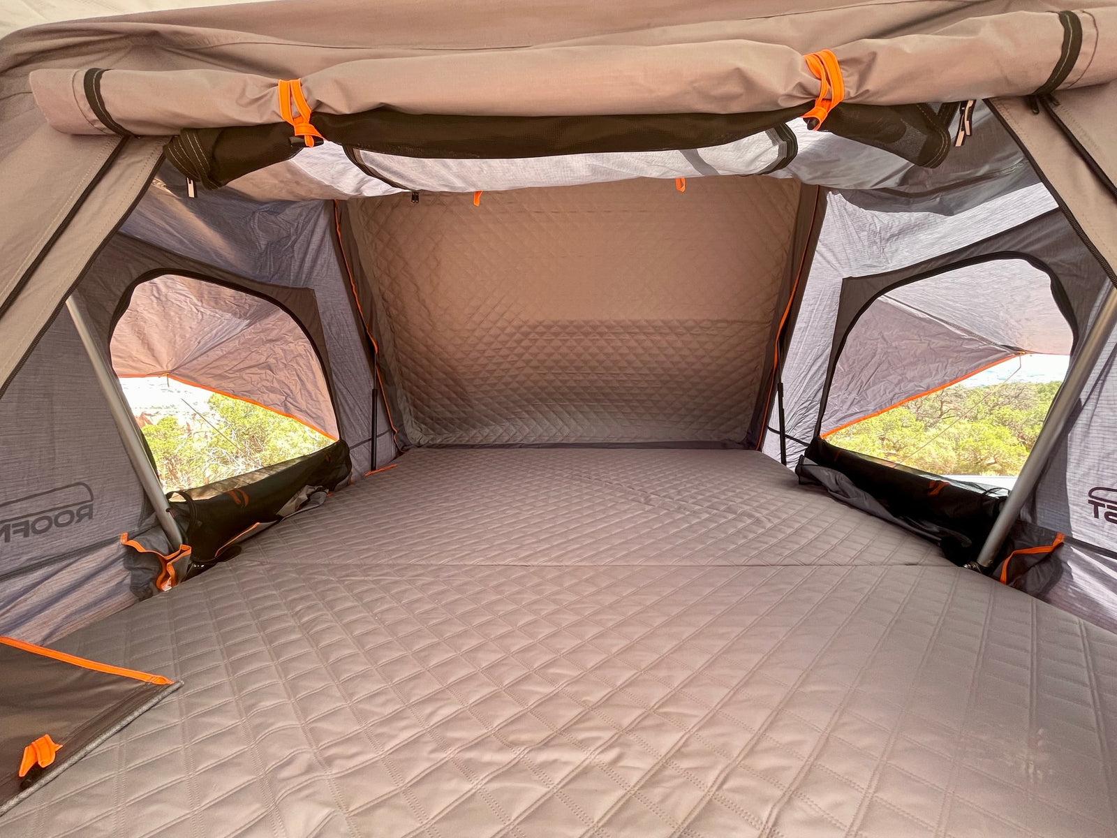 arid landscape.|White Jeep Gladiator overland vehicle with rooftop tent in red rock canyons. Perfect for your adventurous RV rental trip!|This white Jeep Gladiator **RV rental** with a rooftop tent overlooks a scenic valley from a desert cliff