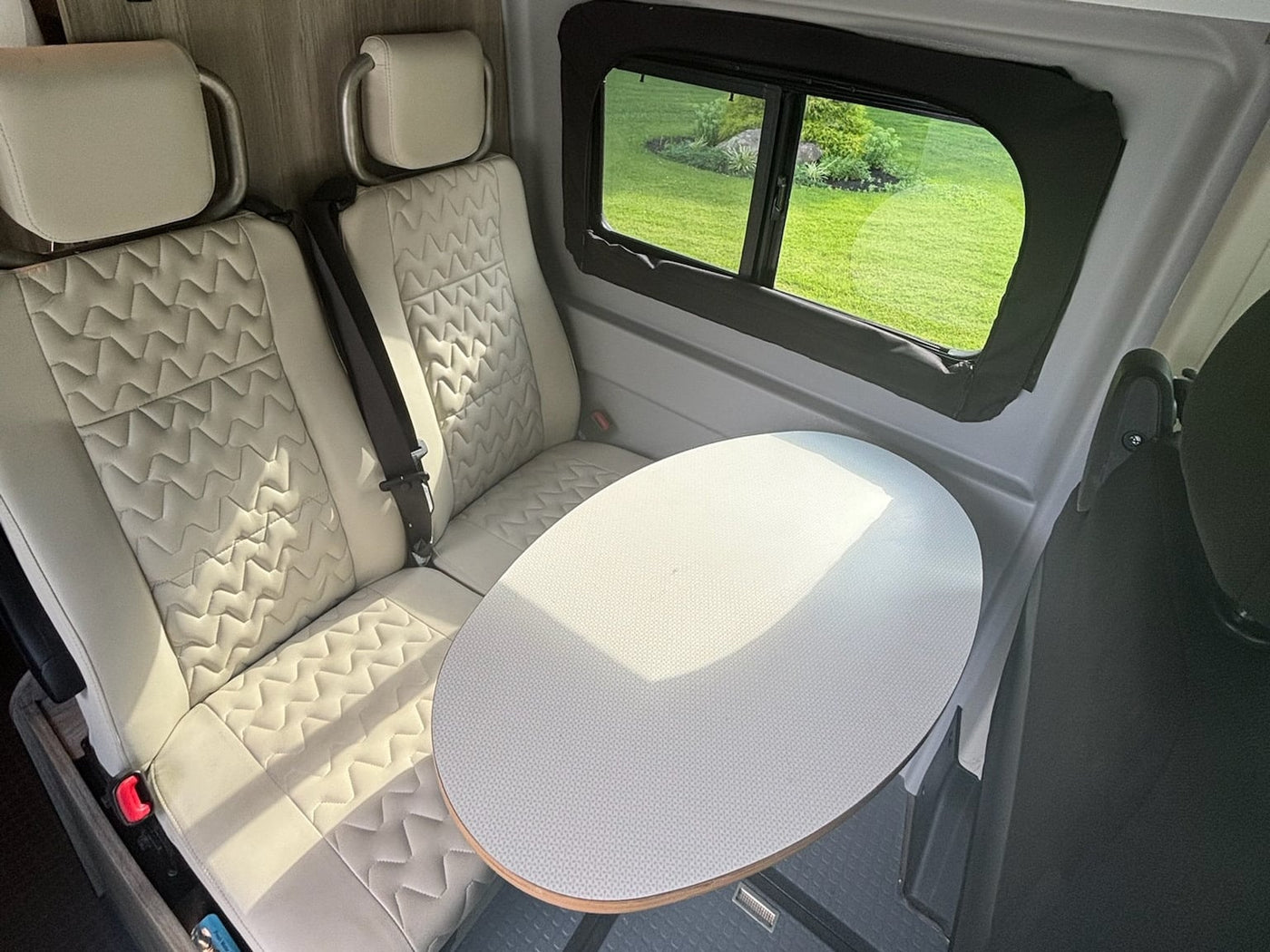 and a fold-down table. Back doors open to nature.|Experience an RV rental: interior with a comfortable bed — photo 9