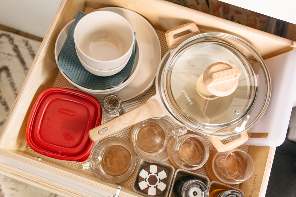 Efficient kitchen drawer organization in your RV rental. Features compact dishes, cookware, and storage essentials for travel.