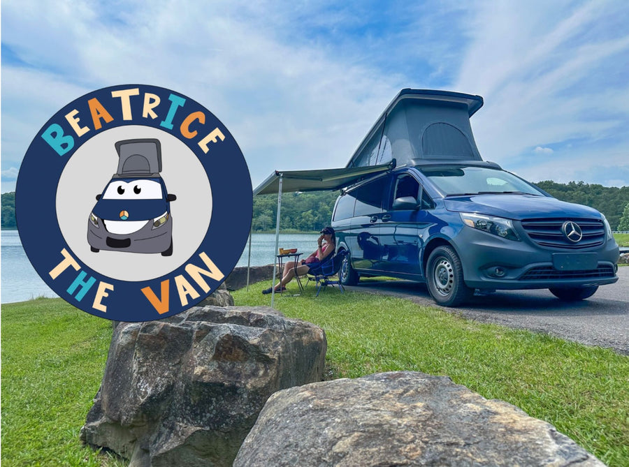 Blue Mercedes-Benz pop-top camper van with awning by a lake