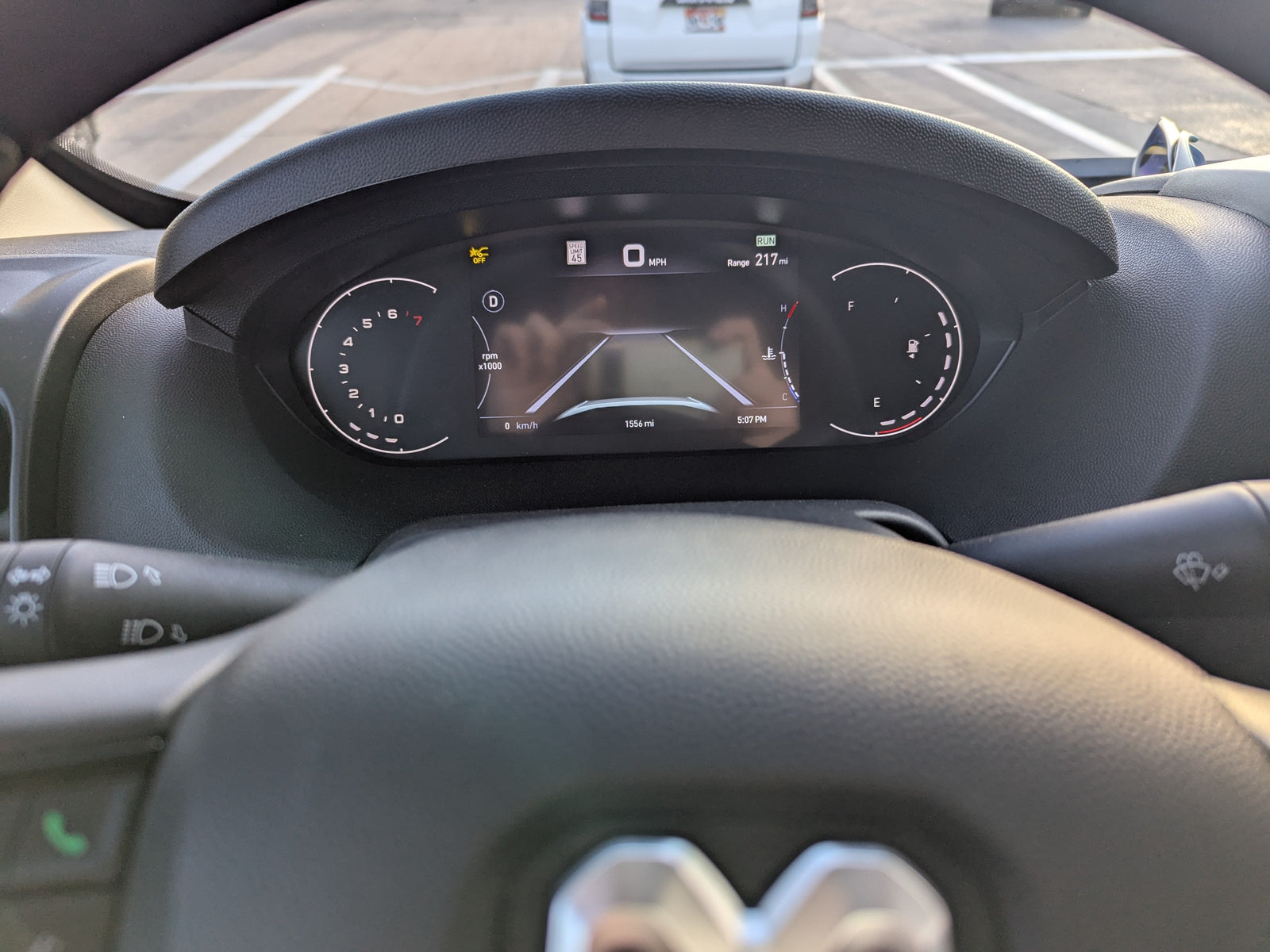 RV rental driving view: dashboard instrument cluster showing 0 MPH, 217-mile range, and 1556 total miles.