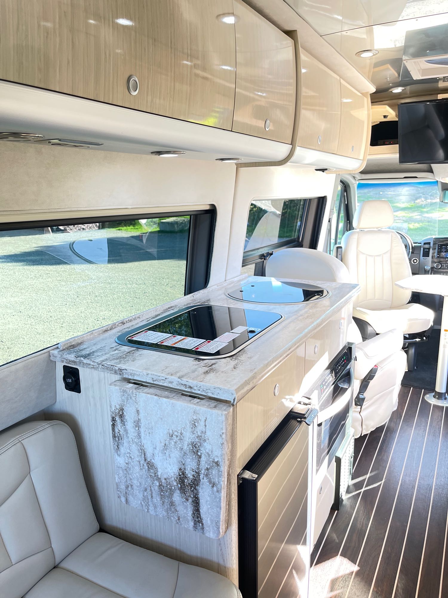 and controls. Enjoy comfortable road trips.|This RV rental's modern interior features a kitchen with built-in cooktops