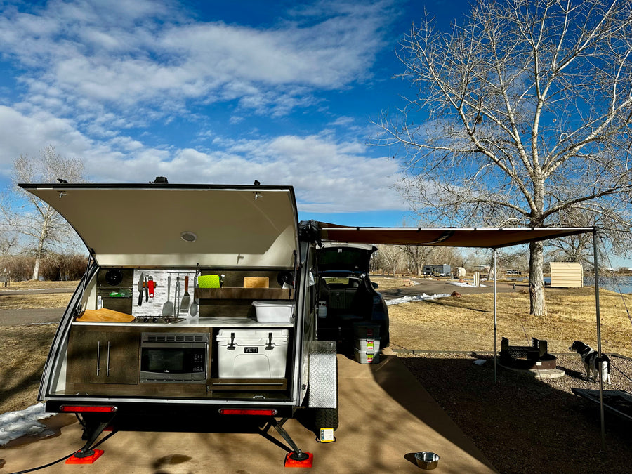 is parked at a snowy campsite under a blue sky