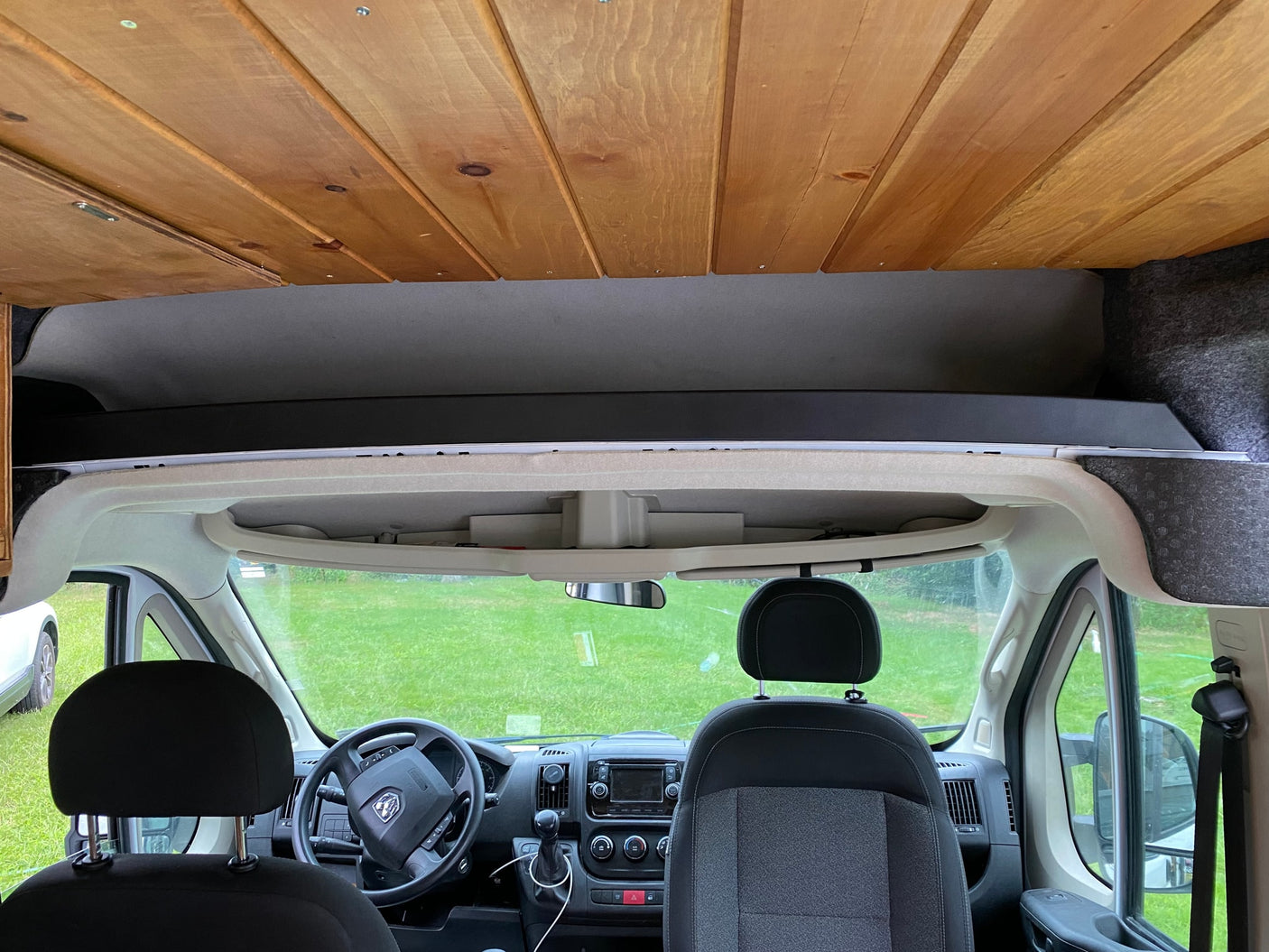 and a cozy sleeping area.|Custom RV rental interior: wood-clad walls & ceiling