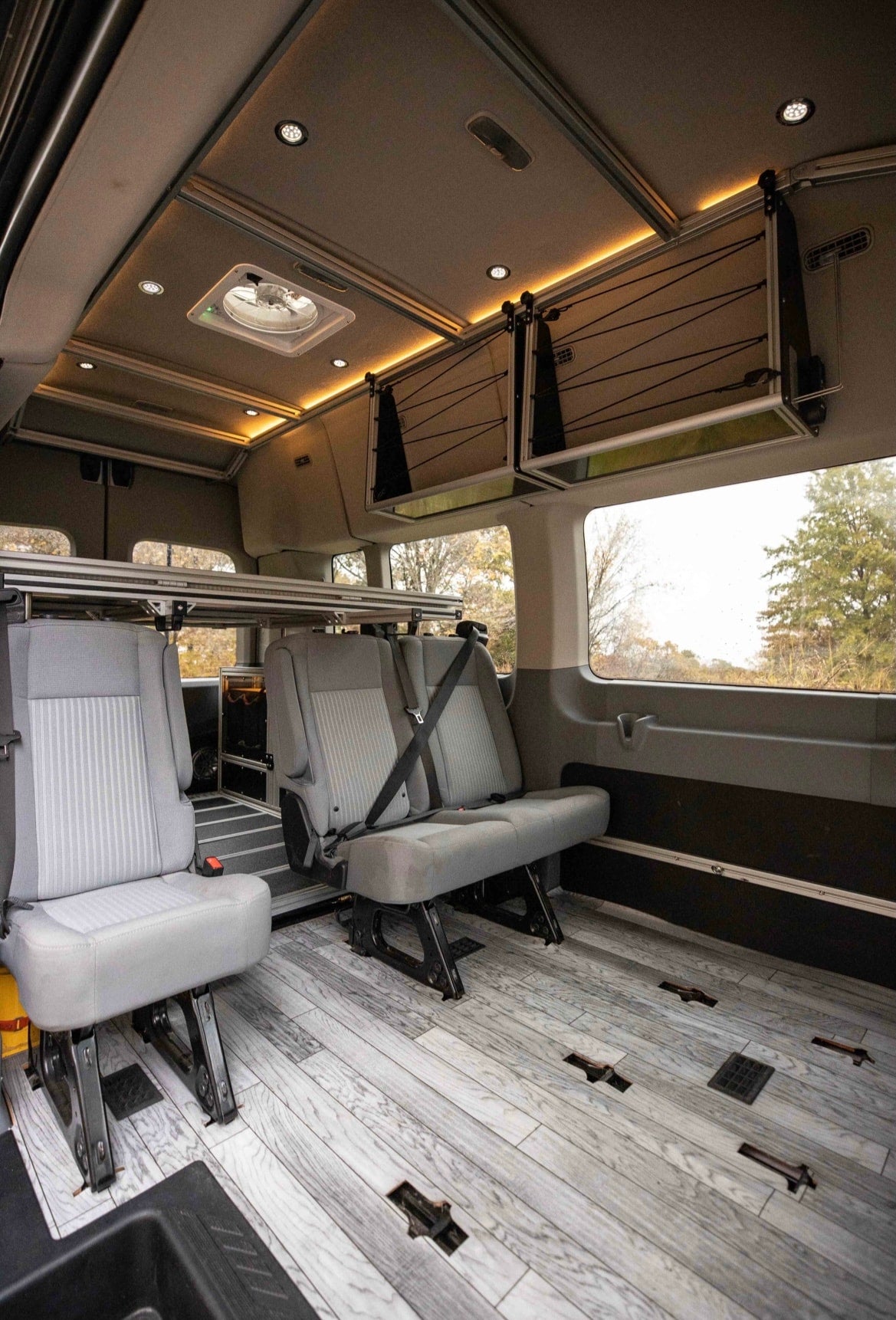 Spacious RV rental interior with modular seating, an adjustable bed system, and overhead storage for flexible travel.