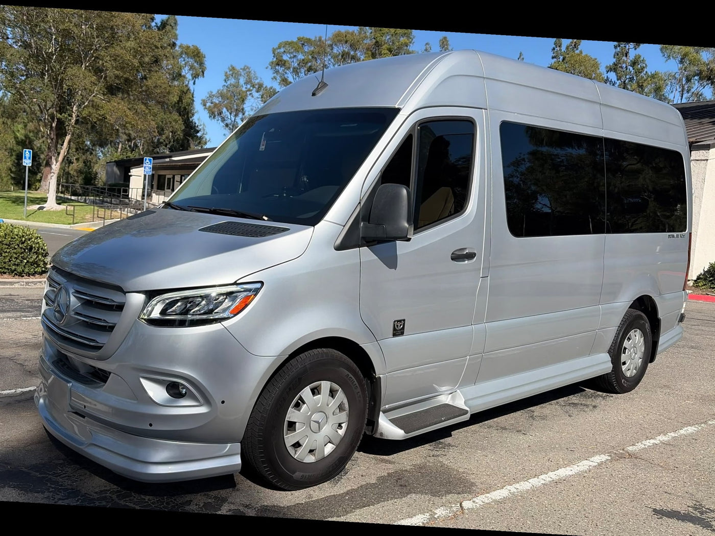 Silver Mercedes-Benz Sprinter luxury RV rental parked outside. This custom conversion van is ready for travel adventures.|Silver Mercedes Sprinter van — photo 1