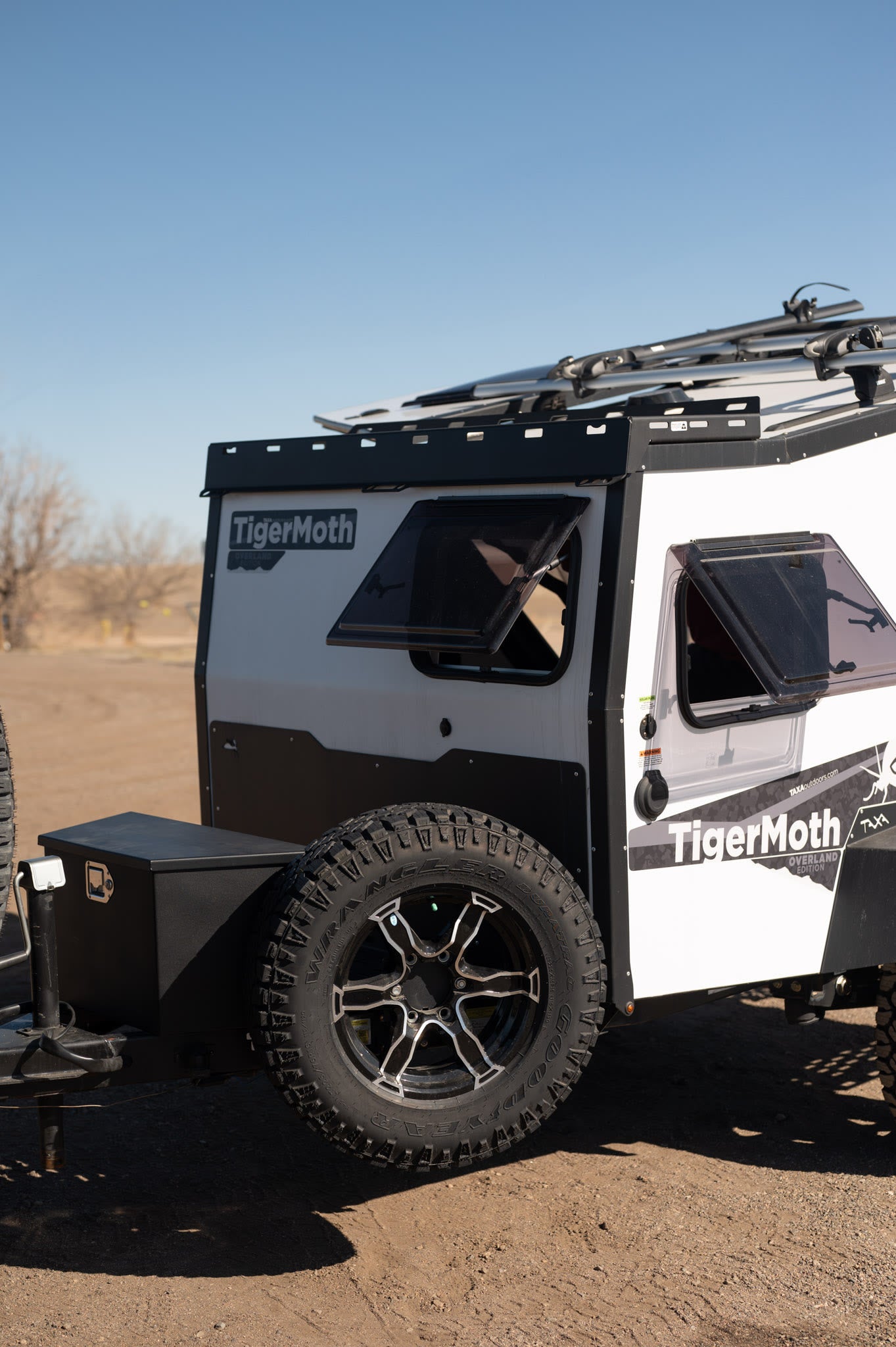 This rugged white and black TigerMoth overland adventure trailer, equipped for off-road travel, is ideal for your next RV rental.