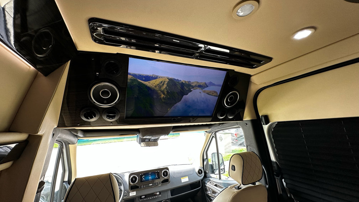 Enjoy a movie in this luxury rv rental, equipped with a large screen, premium audio, and comfortable seating.