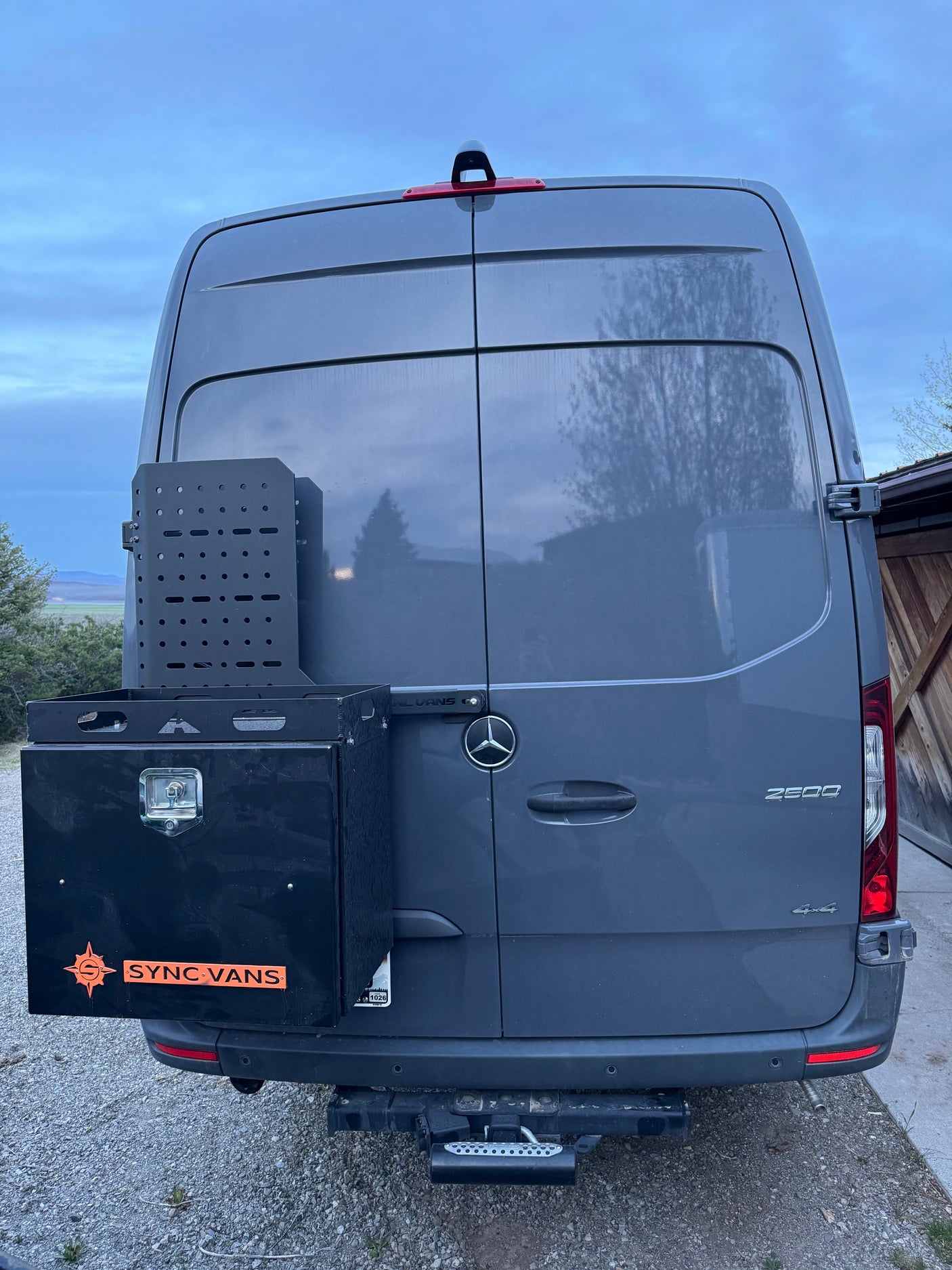 Gray Mercedes Sprinter 2500 4x4 rv rental, with a custom rear storage box, gear rack, and Sync Vans branding.