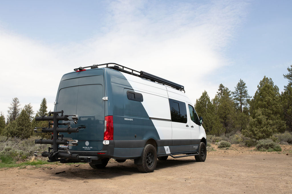 This custom Sprinter camper van, an ideal RV rental, has a bike rack & roof rack for outdoor adventures.